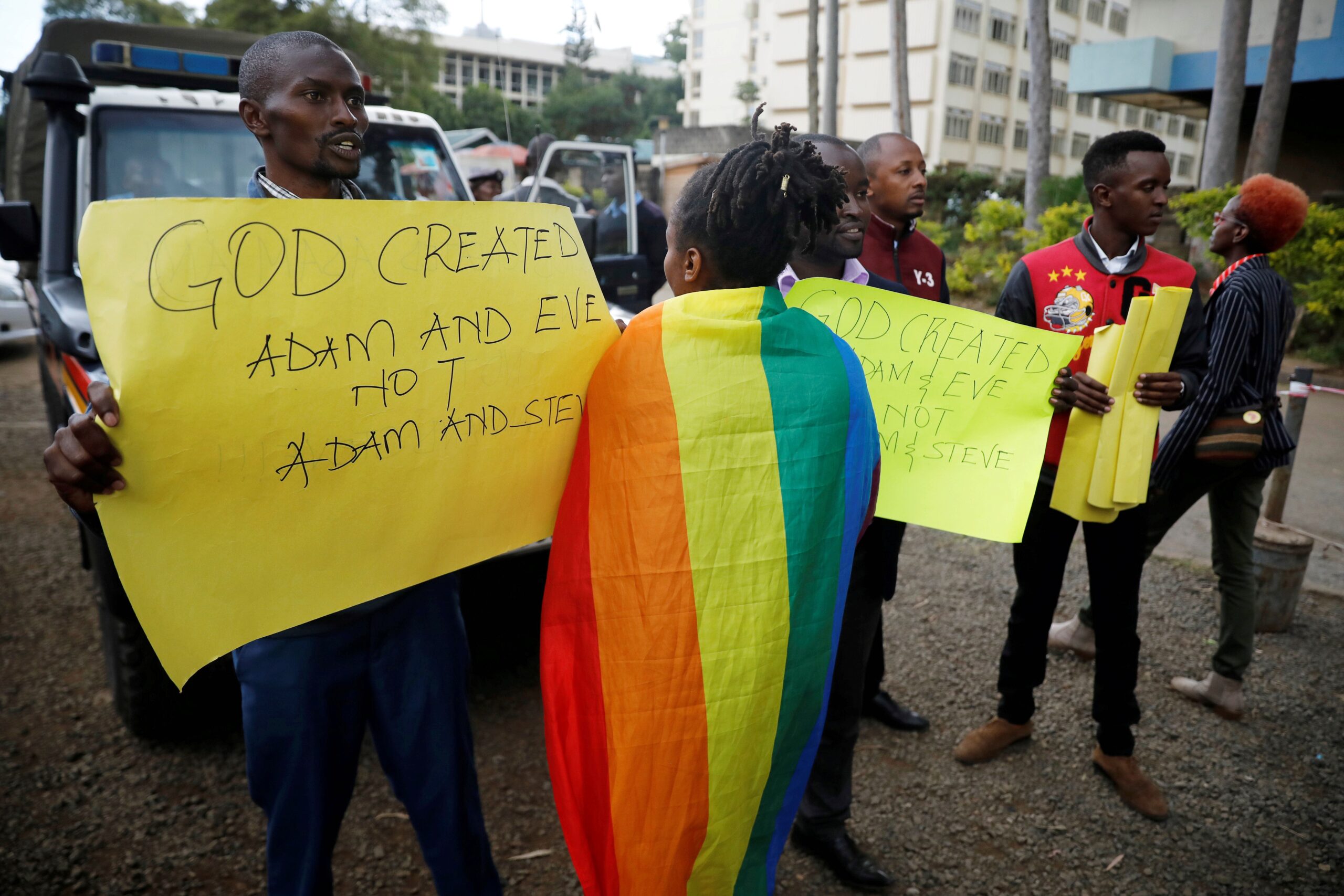 An LGBTQ+ activist walks past anti-gay rights protesters holding placards, after a ruling by Kenya's High Court to uphold a law banning gay sex, in Nairobi, Kenya, on May 24, 2019. Baz Ratner/Reuters